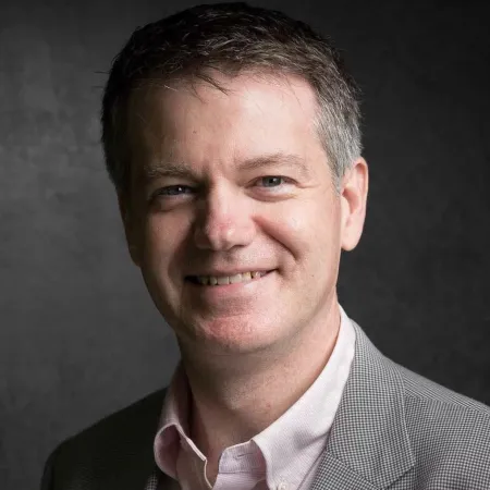 Headshot of Darren Menabney smiling at the camera